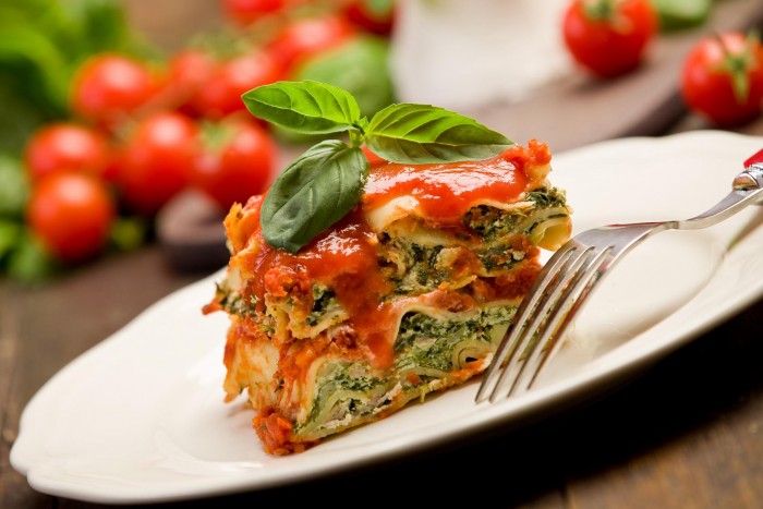 delicious homemade lasagne with ricotta cheese and spinach on wooden table