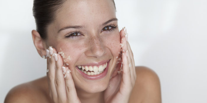 Woman scrubbing sugar on her face