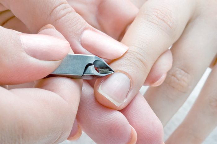 nail salon, manicure applying - cuticle cut using special scissors