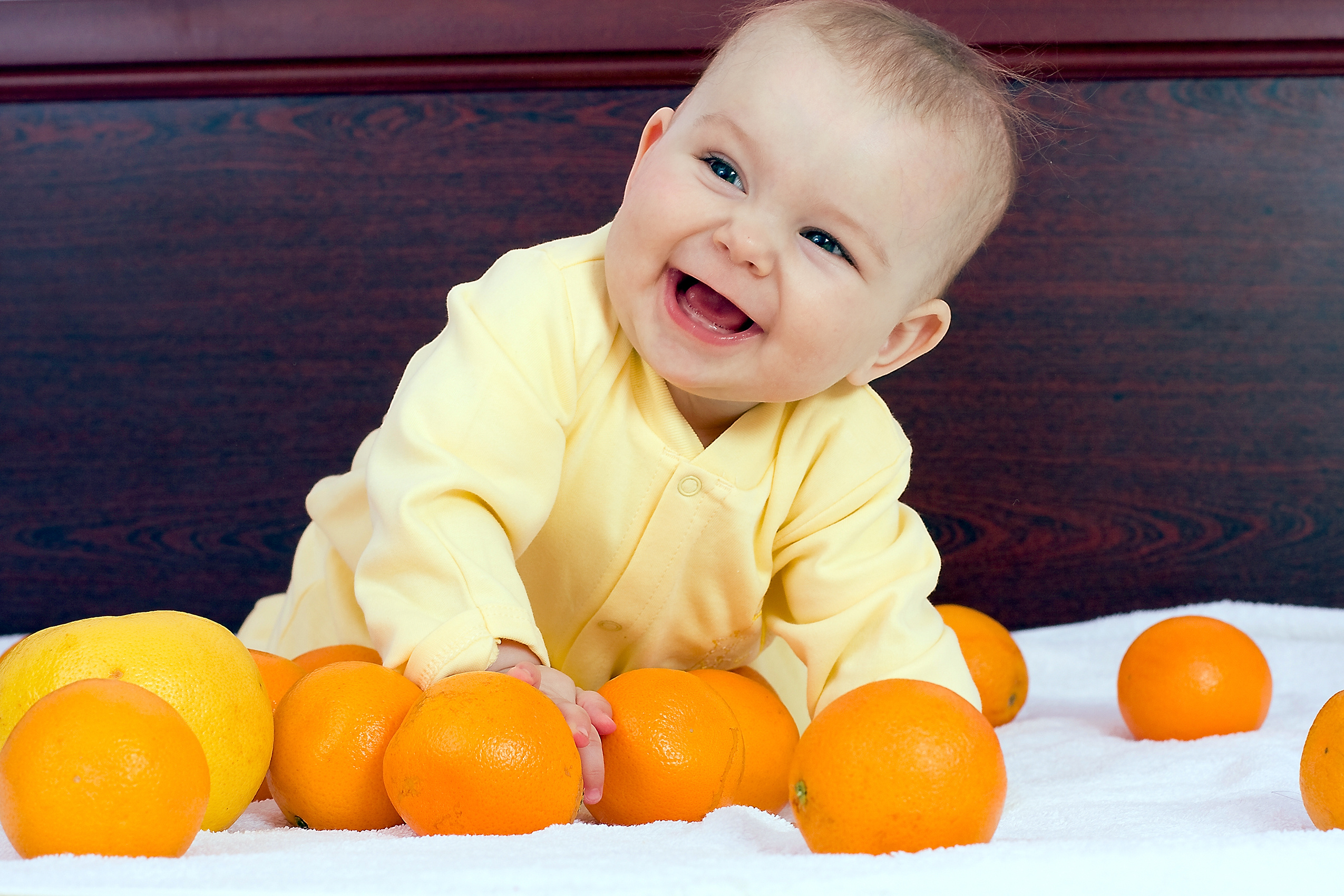 Baby plays with oranges fruits