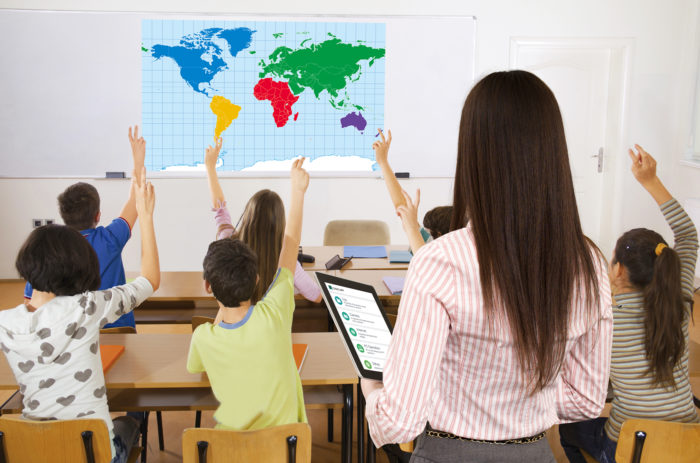 Pupils in classroom responding to the teacher's question.