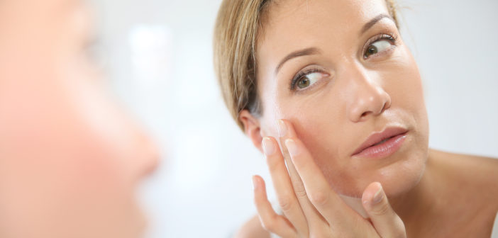 Middle-aged woman applying anti-aging cream