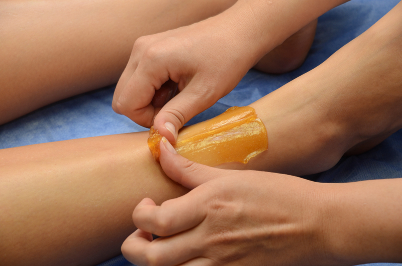 Sugaring: epilation with liquate sugar at legs.