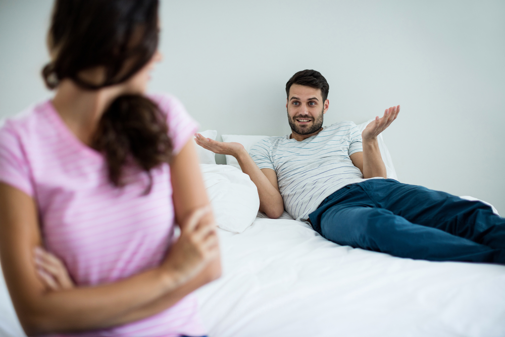 Couple arguing with each other in bedroom at home