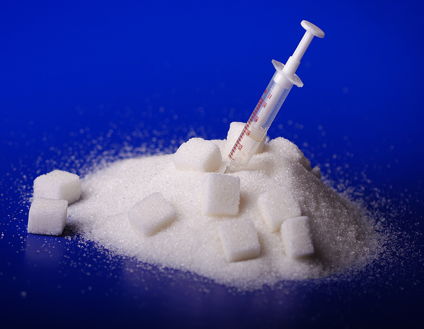 Insulin injection white a pile of sugar
